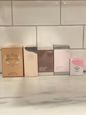 Parfymset med fem olika dofter - 75 kr styck Säljer ett parfymset med fem olika dofter: Cleopatra i beige förpackning, Fearless Optimist i ljusbeige, Solar Blur i brun, White Air i vit och rosa samt Personal Star i ljusrosa. Alla är Eau de Parfum och kommer i snygga, moderna kartonger.
