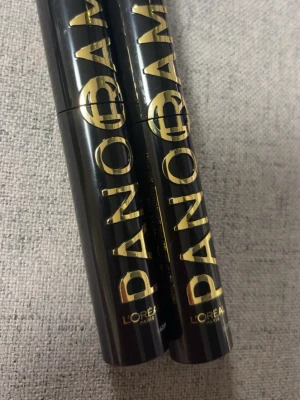 L'Oréal Paris Panorama Mascara - Säljer två svarta L'Oréal Paris Panorama mascaror med elegant guldfärgad text på tuben. Tuben är cylinderformad och tillverkad i plast. Perfekt för att ge fransarna volym och längd med en snygg finish.