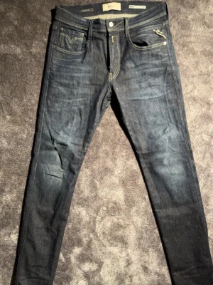 Replay hyperflex slim fit jeans - Säljer ett par mörkblå slim fit jeans från Replay med klassiska gula sömmar och femficksmodell. Jeansen har en skön stretchig denimkänsla. Perfekta till sneakers eller boots för en avslappnad look. Använt en gång. 