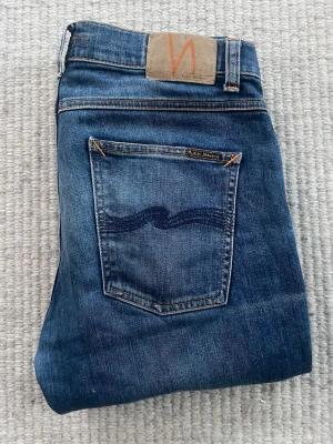 Blå jeans från Nudie Jeans - Nudie jeans! Modell= organic cotton, Skick= 9/10 ny pris= 2000 säljs för endast= 699, hör av er vid minst lilla funderin, priset sitter ej fastspikat vid snabb affär W31 L30 