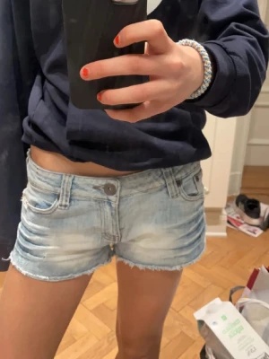 Ljusblå jeansshorts med snygga ränder och bakfickor - Säljer ett par ljusblp assnygga jeans shorts. Super coola ränder samt fickor med fint glitter. Jag skulle säga att storleken är 36/38 passar mig bra jag brukar ha 34-36
