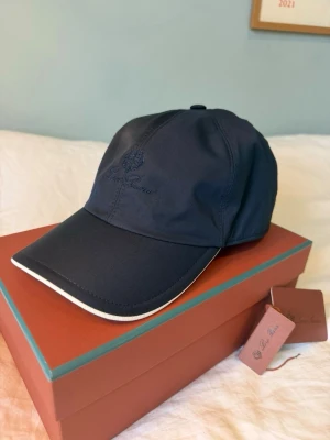 Loro Piana Storm System Cap – Storlek XL (Fullset) - Säljer en extremt fräsch Keps från Loro Piana i deras kända "Storm System"-material (vind- och vattentålig). Riktigt stilren mörkblå/navy färg med kontrasterande vit undersida av skärmen. 