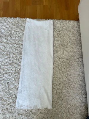 Vit kjol från SAMSA Collection - Säljer en vit kjol från SAMSA Collection i storlek XS. Kjolen har en rak passform och resår i midjan för extra komfort. Materialet är luftigt och perfekt för varma dagar. Enkla att matcha med olika toppar för en clean look.