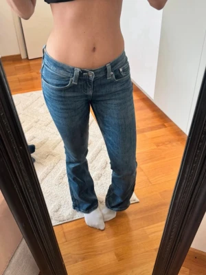 Blå bootcut jeans med låg midja - Sööötttaaa som tyvär ej kommer till användning  blåa Lågmidjade lowwaist jeans från ginatricot med lite detaljer, inga defekter endast använda 3 gånger.