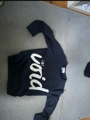 Svart sweatshirt från Jack & Jones - Cool svart sweatshirt från Jack & Jones med stor vit text 'void' på framsidan. Tröjan har rund halsringning och långa ärmar. Perfekt för dig som gillar streetwear och vill ha en avslappnad stil.