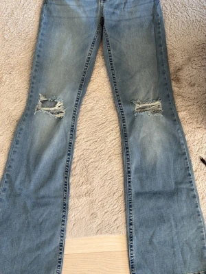 Ljusblå slitna jeans från Nelly - Ljusblå jeans från Nelly med raka ben och slitningar över knäna. Klassisk femficksmodell i mjuk denim med snygg tvätt och råa detaljer. 