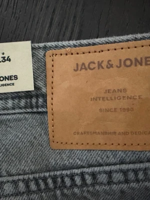 Grå jeans från Jack & Jones - Snygga grå jeans från Jack & Jones. Helt nya jeans med orginalpriset 600kr. Storlek 29/34
