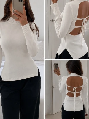 Vit stickad topp med öppen rygg - Trendig vit stickad topp med lång ärm och polokrage. Baksidan har en öppen design med två knytband som ger en unik och snygg detalj. Perfekt för dig som vill ha en enkel men ändå statement stickad tröja. Materialet känns mjukt och stretchigt. Som ny, endast använd en gång. Material: 79% viskos, 21% Polyester 