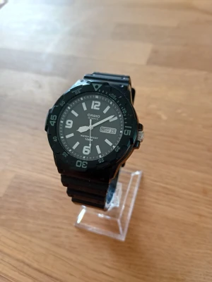 Casio Timeless Diver 43mm Herrklocka - Säljer en snygg stilren herrklocka från japanska Casio i nyskick enligt bilder. Enstaka repor som ej syns. Fungerar bra, originalarmband i harts, dag och datumvisare, japanskt urverk, vattentät, akrylglas, roterande dykarring, självlysande Neo-display osv. Behöver bara nytt batteri. Modell: MRW-200H. Se detaljer längst ned.  Nypris: 600 SEK Mitt pris: 489 SEK  Skriv vid frågor och se gärna mina andra annonser! Skapar gärna deals och paketpriser för just dina behov!   Skickas snabbt och spårbart 