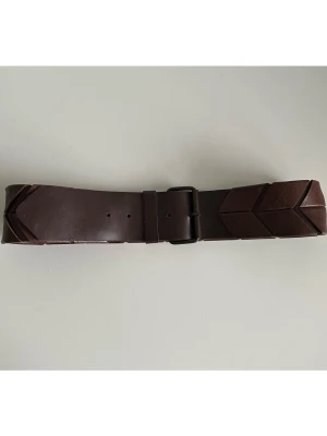 Unikt brunt bälte i 100% äkta läder - Unikt brett bälte / skärp i mörkbrunt skinn (100% äkta läder) med unika pilformade sektioner och vackert präglade mönster. Spännet är i matchande mörk ton och bältet har en trendig, geometrisk look. 6 cm brett och 101 cm långt, passar midjemått på mellan 81-91 cm, motsvarande storlek M-L. Tidlöst coolt och rejält geometriskt kvalitetsskärp som kommer hålla år efter år. Mycket gott skick. 