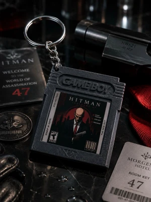 Game Boy nyckelring med Hitman-motiv - Cool nyckelring formad som ett Game Boy-spel med Hitman-motiv. Nyckelringen är svart och silverfärgad, tillverkad i plast och metall. Perfekt accessoar för dig som gillar gaming och retrostil.