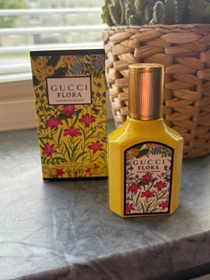 Gucci Flora Gorgeous Orchid parfym - Gucci Flora Gorgeous Orchid parfym i en snygg gul flaska med guldigt lock och blommigt mönster på etiketten. Förpackningen har samma färgglada blommiga design som flaskan. Perfekt för dig som gillar exklusiva och unika dofter. 30ml endast testad 