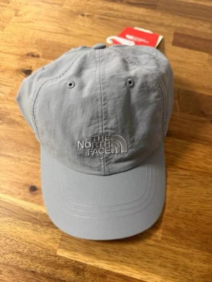 The North Face Horizon keps L/XL - Säljer helt ny oanvänd The North Face Horizon keps i färgen Mid Grey. Storlek L/XL. Denna kepsen köptes in på TNF hemsida för flera år sedan och har aldrig använts.