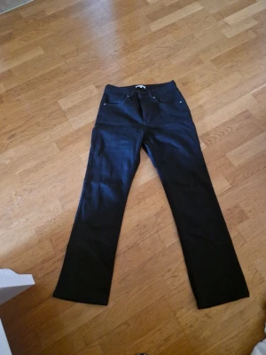 Svarta bootcut jeans från Rosebud - Säljer ett par svarta stretch jeans från Rosebud i storlek 40. Jeansen har klassisk femficksmodell, raka ben med lätt bootcut och bälteshällor. Materialet är denim med en snygg svart tvätt. Perfekta för dig som gillar en tidlös och clean look.