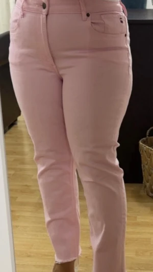 Ljusrosa jeans från Tommy Hilfiger - Säljer ett par ljusrosa jeans från Tommy Hilfiger med klassisk femficksmodell och raka ben. Jeansen har råa kanter nertill och diskret logga på bakfickan. Perfekta för dig som vill sticka ut med färg! Materialet är mjukt denim med lite stretch. Köpta från usa och inte använda.
