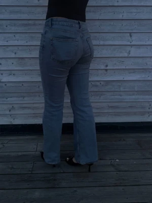 Grå bootcut jeans med medel hög midja.  - Snygga blåa jeans med bootcut passform och medel hög midja. Klassisk femficksmodell och raka ben som slutar i en lätt utsvängning. Perfekta till sneakers eller klackar. Pris går att diskutera!!