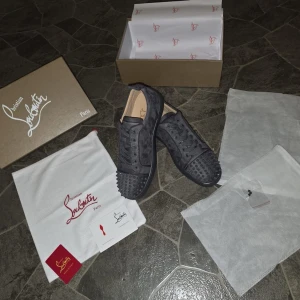 Christian Louboutin gråa sneakers - Använd endast 1-2 gånger på bal, ny skick på de. Super snygga nu inför sommarn. Kommer med låda och lite olika saker som syns på bilden. Råkade slänga skohornet 😪🤦🏻men resten är i perfekt skick, vid frågor och funderingar är det bara och att fråga på ☺️pris kan diskuteras 🙏