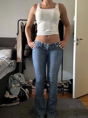 Blå bootcut jeans med låg midja - Säljer ett par ljusblå bootcut jeans från true religion i storlek 26. Jag är 164 cm till referens. Jeansen är i bra skick men är sliten på ena byxbenet längst ner. Pris kan diskuteras.