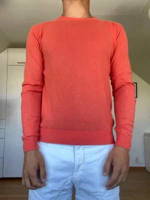 Korallröd stickad tröja - Korallröd stickad tröja från Hansen & Jacob tillverkad i bomull, nylon och silke. Strl S. Inga defekter. Modellen är 178 cm och väger 77 kg. Hör gärna av dig vid frågor!