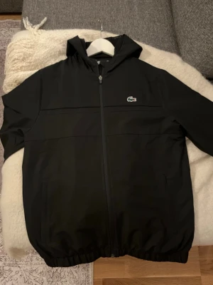 Lacoste dress - Svart dress från Lacoste med klassisk krokodillogga på benet. Byxorna har resår i midjan och vid benslut för en skön passform. Perfekta för en avslappnad och sportig stil. Materialet är mjukt och bekvämt.
