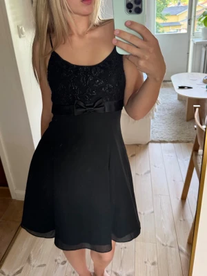 Fin svart klänning - Jättefin klänning köpt i Spanien men glitter och en liten rosett 🎀🎀 står ingen storlek men skulle säga att den passar M/L🖤🖤