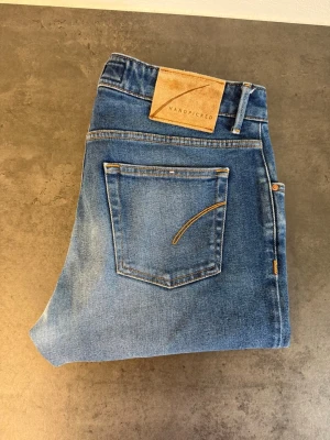 Blå jeans från Handpicked W34 - Snygga blå jeans från Handpicked med klassisk femficksdesign och raka ben. Jeansen har en ljus tvätt med subtila slitningar och kontrastsömmar. Tillverkade i mjuk bomullsdenim för en bekväm känsla. Perfekta för en avslappnad och trendig stil.