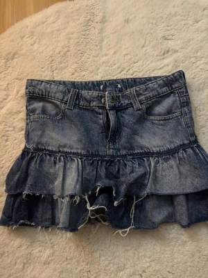 Blå volangkjol i denim - Snygg kort jeanskjol med volanger från Gina Young. Kjolen är i stolek 158, dock är lappen avklippt då jag gillade att vika ner kjolen och ej ville att lappen skulle synas, men det är i stolek 158. Skulle säga att den är lite större i stoleken. Skriv om ni har någon fråga!!💗💗