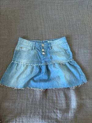 Ljusblå jeanskjol med volang - Jätte fin lågmidjad jeanskjol med volang från Esprit med fransig kant. Materialet är superskön och den sitter perfekt. Dock passar den inte längre på mig så kan inte fota på. Fråga om mått!