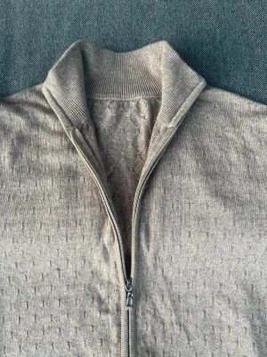Beige ziptröja med strukturmönster - Snygg beige ziptröja med diskret strukturmönster och hög krage. Exklusiv handgjord tröja.  100% äkta kashmir - mjuk, varm o mysig  Beige färg som passar allt   Unik kvalitet som ej finns i butik  Perfekt för vardag och jobb