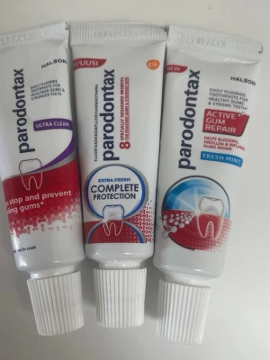 Parodontax tandkräm 3-pack - Tre tuber Parodontax tandkräm i olika varianter: Ultra Clean, Complete Protection Extra Fresh och Active Gum Repair Fresh Mint. Tubarna är vita med röda, blå och lila detaljer. Perfekt för dig som vill ta hand om tandköttet och få fräsch andedräkt.