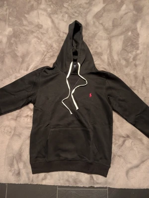 Polo Ralph Lauren hoodie svart - Säljer en svart Ralph Lauren hoodie i svart storlek L men passar även M. Använd ett fåtal gånger