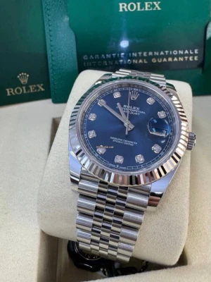 Rolx klocka  - Snygg klocka, silverfärgat stålarmband. Klockan har räfflad bezel, datumfönster och timmarkeringar med diamanter. Klassisk och exklusiv design som sticker ut på handleden.