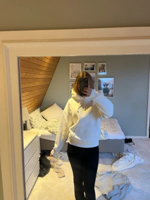 Bik bok hoddie  - Säljer en vit oversized hoodie med stor huva och dragsnören. Hoodien har en klassisk känguruficka framtill och ribbade muddar vid ärmslut och nederkant. Perfekt för en chill och avslappnad stil. Materialet känns mjukt och bekvämt, troligen bomull eller bomullsblandning. 