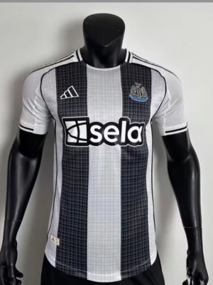 Newcastle United matchtröja Adidas - Snygg Newcastle United matchtröja från Adidas i svart och vitt med klubbmärke på bröstet och sponsorlogga 'sela' framtill. Tröjan har korta ärmar, rund hals och klassiska Adidas-detaljer. Perfekt för fotbollsfans och sportiga tillfällen.