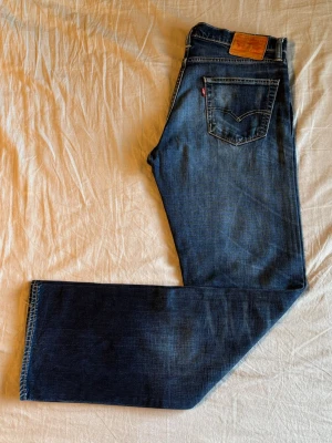 Levi's 504 - Klassiska blå jeans från Levi's med raka ben. Storlek: W34 L34. Mått: Midja - 42.5 cm  Längd - 107 cm Innerbenslängd - 83 cm Fotöppning - 21 cm Lår - 28 cm