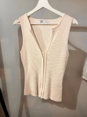 Beige ribbad topp från Zara - Säljer en beige ribbad topp med v ringning från zara!! slutsåld, i storlek L men sitter som M