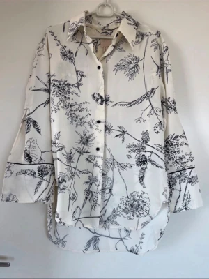Vit skjorta med svart blommigt mönster - Strl S. Hm