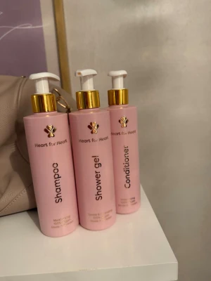 Heart for Heart hår- och kroppsvårdset - Säljer ett set med duschgel, balsam, hårolja och schampo från Heart for Heart. Produkterna kommer i rosa flaskor med gulddetaljer och pumpfunktion. Perfekt för dig som vill ha ett matchande och stilrent kit i badrummet.