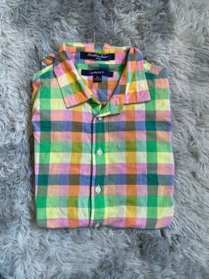 Rutig skjorta i pastell från GANT - Färgglad rutig skjorta från GANT i pastellfärger som grön, gul, rosa, orange och blå. Skjortan är i bomull, har klassisk krage och knäppning framtill. Perfekt för dig som gillar en färgstark och unik stil.Priset kan diskuteras vid snabb affär 