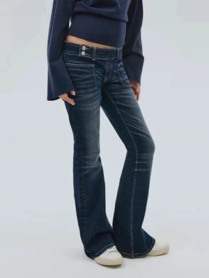 Mörkblå jeans - Snygga mörkblå, lågmidjade, bootcut jeans med lätt slitna detaljer och kontrastsömmar. Jeansen har låg midja, klassiska fem fickor och stängs med knapp och dragkedja. Perfekta för en avslappnad och trendig look.