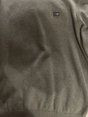 Olivgrön tröja från lexington - Snygg olivgrön tröja från lexington med rund halsringning och diskret logga på bröstet. Tröjan har ribbade muddar vid hals och nederkant, perfekt för en clean och stilren look. Materialet känns mjukt och bekvämt. Aldrig använd 