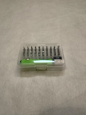 PrecisionsSkruvmejselset med grönt handtag - Praktiskt skruvmejselset i plastlåda med grönt handtag och flera olika bits i metall. Perfekt för mobiltelefon reparationer, småfix hemelektronik eller till hobbyprojekt. Lådan är genomskinlig så du ser alla delar direkt och handtaget har ergonomisk form för bättre grepp.