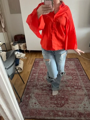 Röd skjorta med vida ärmar - Säljer en röd skjorta med riktigt vida och långa ärmar. Skjortan har klassisk krage och knappar framtill. Materialet känns som bomull och modellen är loose fit för en avslappnad vibe. Pris kan diskuteras