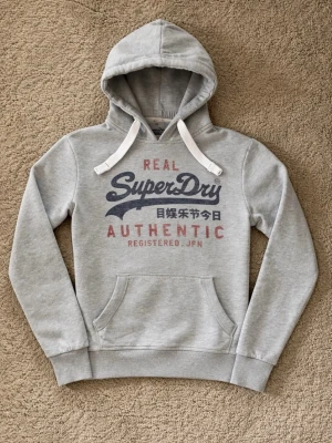Superdry Hoodie - Snygg grå hoodie från Superdry. - Eftertraktad Colourway ganska svår att få tag på. - Storlek: M men sitter som S - Pris: 599kr - Först till Kvarn!