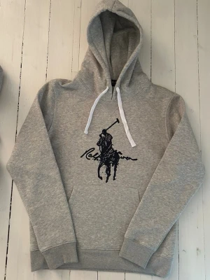 Ralph Lauren hoodie herr, storlek S  - Hej! Säljer denna riktigt schyssta hoodie från Ralph Lauren. Den är i storlek M men sitter en storlek litet och passar därför som en S. Den är endast använd någon enstaka gång och är därmed i ett nyskick. Original lappar och påse finns kvar och medföljer naturligtvis vid köp. Jag fraktar alltid snabbt! Mvh