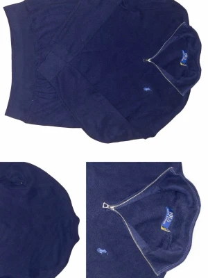 Mörkblå halvzip från Polo Ralph Lauren - Mörkblå tröja med halv dragkedja från Polo Ralph Lauren. Klassisk broderad logga på bröstet i ljusblått. Ribbstickade muddar vid ärmslut och nederkant. Perfekt för lager på lager och en clean look.