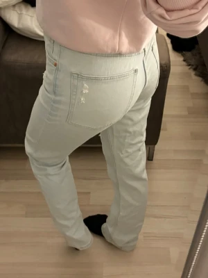 Vintage straight jeans ljusblå - Ljusblå jeans från H&M med vintage straight passform, hög midja och prislappen kvar. Klassiska femficksdetaljer och slitningar. Materialet är denim och byxorna har raka ben som ger en avslappnad look. Aldrig använda! 