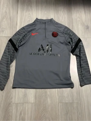 Grå PSG träningströja från Nike - Mörk grå psg tröja storlek 158-170 inge defekter eller skador kan säkert passa dom som har xs.