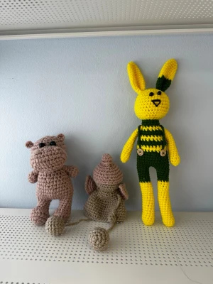 Virkat gosedjur - Styckpris: 150kr!  Set med tre virkade gosedjur. En gul och grön kanin, en brun flodhäst och en beige och rosa elefant. Kaninen är 35 cm lång. Flodhästen är 18 cm lång. Elefanten är 15 cm lång. Pris kan diskuteras vid köp av fler.