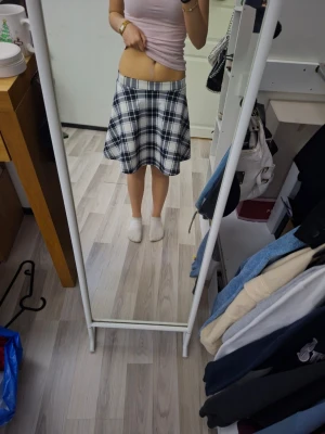 Rutig kortkjol i svart och vitt - Säljer en snygg rutig kortkjol i svart och vit. Kjolen har ett skönt tyg mot kroppen. Perfekt för dig som gillar preppy stil och vill ha en kjol som sticker ut lite extra. Använd ändast nån gång.